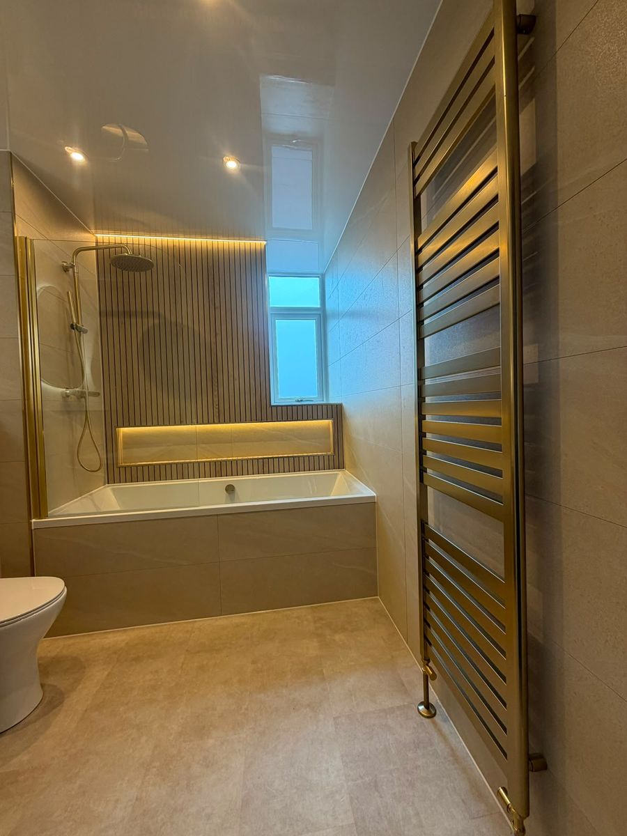 Brushed brass towel radiator in a renovated bathroom