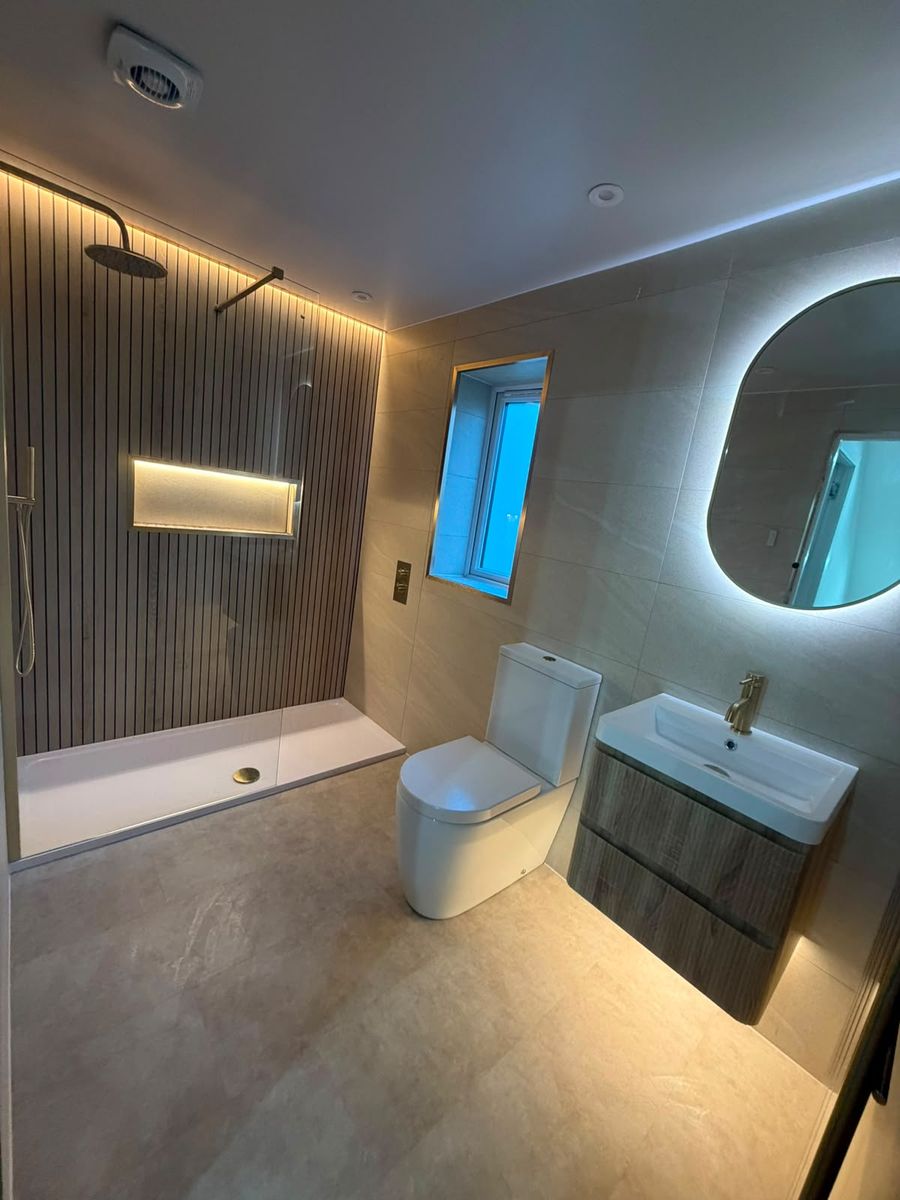 Backlit mirror and LED cove lighting in a dark evening bathroom